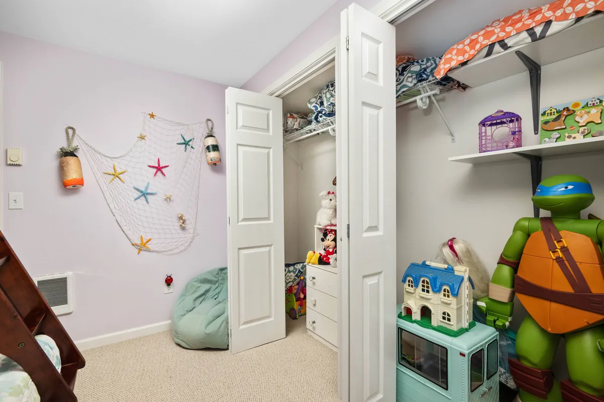 A cheerful kids' playroom with colorful storage bins, a bean bag chair, themed décor, and a variety of toys. The playful setup signals a family-friendly environment where young guests can play and relax.